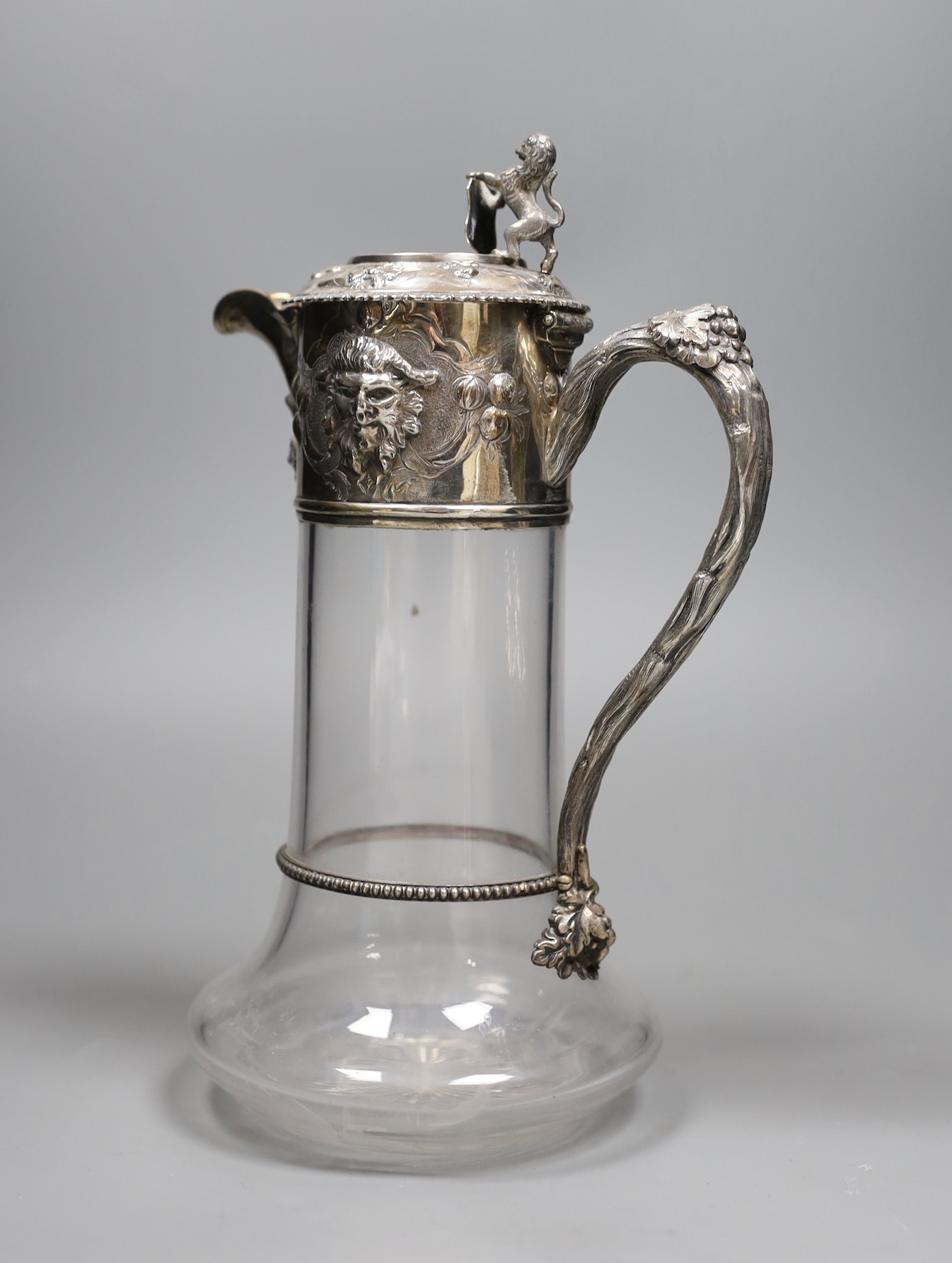 A Victorian silver mounted glass claret jug, by Richards & Brown, London, 1862, 26.9cm, decorated with masks and lion finial.